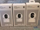 trois boîtes blanches contenant un appareil photo, posées sur un comptoir