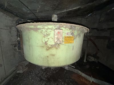 a large green pot sitting inside of a dirty room