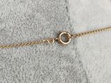 a close up of a gold chain bracelet on a white blanket