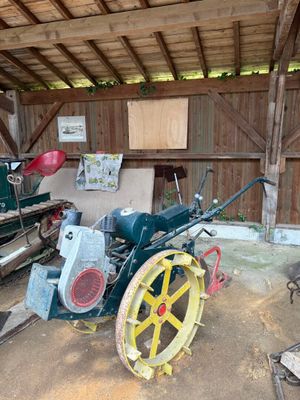 un petit tracteur garé à l'intérieur d'une grange