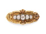 un gros plan d'une broche en or et diamants sur fond blanc