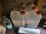 quatre récipients contenant un liquide posés sur un plan de travail, à côté d'une bouteille d'alcool
