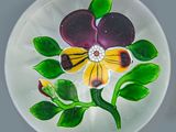 une assiette en verre ornée d'une fleur, posée sur une table