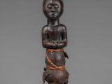 a carved wooden figure of a woman with a bird on her shoulder
