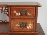 a small wooden desk with three drawers on top of it