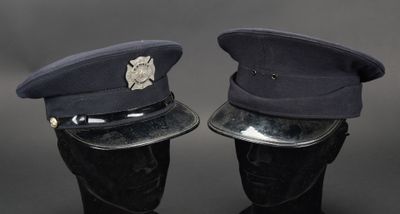 une paire de casquettes de police posées sur des têtes de mannequins, sur fond noir