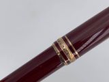 an image of a red pen with gold trims on it