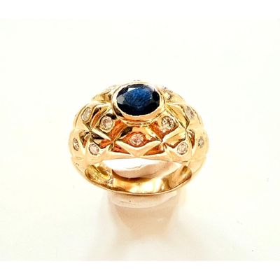 une photo en gros plan d'une bague sertie d'une pierre bleue