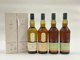 quatre bouteilles de whisky devant une boîte en carton