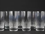 six verres transparents sont alignés sur une surface noire
