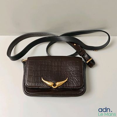 une image représentant un sac à main marron orné d'un oiseau doré