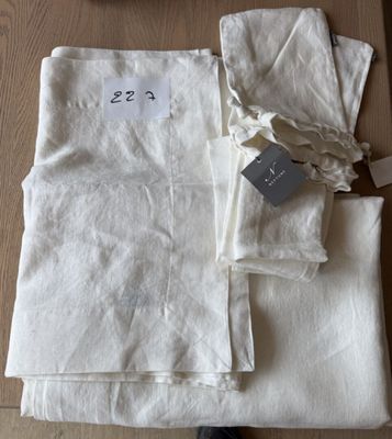 une pile de linge de maison blanc plié posée sur une table en bois