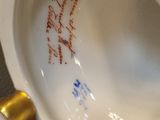 a white porcelain toilet with writing on the lid