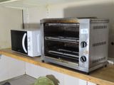 une photo d'un four grille-pain et d'un micro-ondes posés sur un plan de travail de cuisine