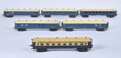 six blue and yellow train cars sitting next to each other on a white surface