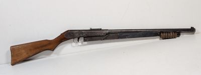 an old shotgun with a wooden handle on a white surface