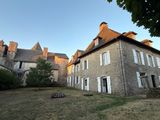 a large stone building with white shutters in front of it