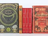 trois livres superposés sur une surface blanche