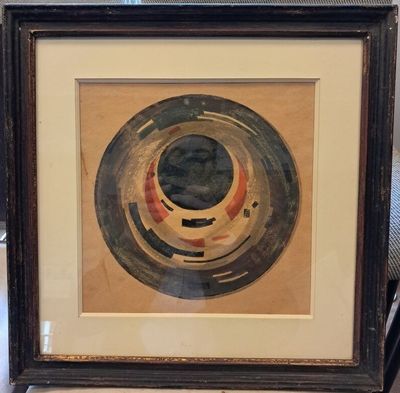 painting of a circular design in a black frame on a table