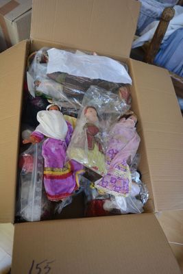 a cardboard box full of dolls and other items