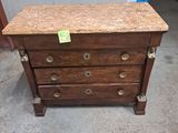 une commode en bois avec un plateau en marbre, dans un garage