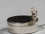 a small silver box with a bear on top of it
