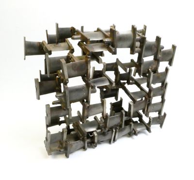 a sculpture made of metal pieces on a white surface