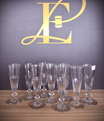 several empty wine glasses lined up on a table with the letter p in the background