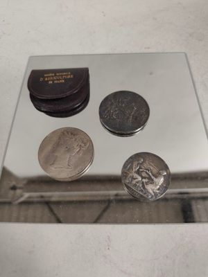 trois pièces posées sur un miroir posé sur une table