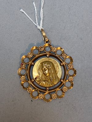 un gros plan d'une médaille d'or sur laquelle figure le portrait d'une femme