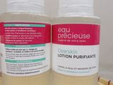 two bottles of clean skin lotion sitting on top of a bamboo mat