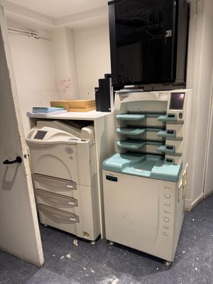 an image of a room with a tv, printer, and cabinets