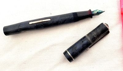 un stylo noir et un stylo rouge posés sur un tissu blanc