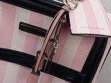 a pink and black suitcase with a tag attached to it