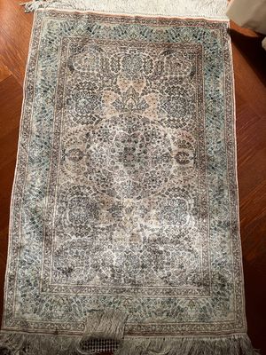 un tapis oriental posé sur un parquet dans un salon