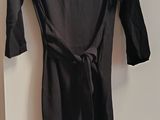 a black dress hanging on a hanger in a room