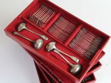 a red box with silverware in it on a white surface