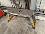 un banc en béton posé dans un garage, à côté d'une caisse à outils rouge