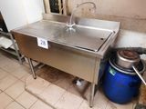 un évier en inox dans une cuisine où se trouve un seau bleu