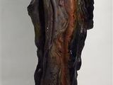 statue d'une femme assise sur une branche d'arbre, un oiseau dans la main