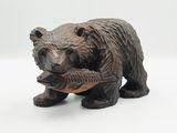 une statue représentant un ours tenant un poisson dans sa gueule