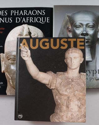 deux livres posés sur une table, à côté d'une statue d'homme et d'une statue de femme