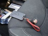 a car seat with a bottle of beer and a keychain
