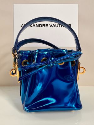 a blue handbag sitting on top of a table next to a box
