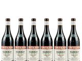 six bouteilles de vin sont alignées sur une surface blanche