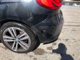a black car parked in a parking lot with a shadow of a person on the ground