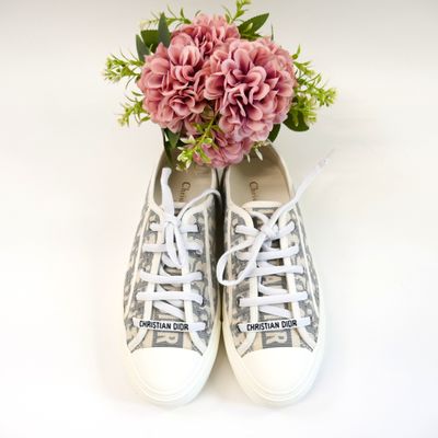a bouquet of pink flowers sitting on top of a pair of sneakers