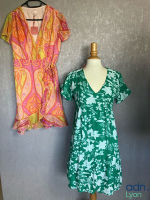 two dresses on a mannequin stand next to each other