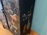 a black cabinet with a vase on top of it
