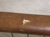 a close up of a wooden rail with a rusted paint on it